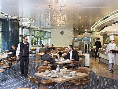 Huéspedes disfrutando del desayuno en el elegante restaurante Ambiente del Maritim Hotel Frankfurt.