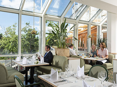 Restaurant spacieux au Maritim Hotel Würzburg avec grandes baies vitrées et coin salon accueillant