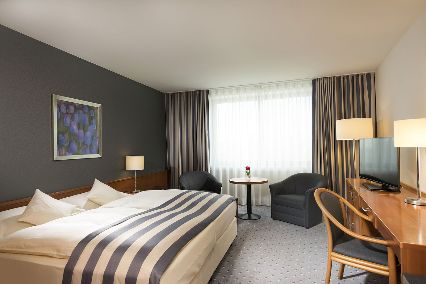 Amplia habitación doble en el Maritim Hotel Ulm con luz natural y zona de estar